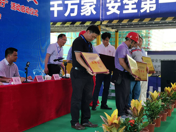 项目负责人陈文勇（左）代表项目部上台领取建筑施工安全生产先进单位奖.jpg